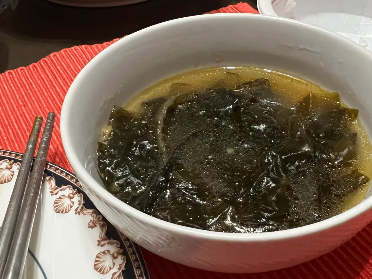 Korean seaweed soup (miyeok guk) in a white bowl on a red placemat